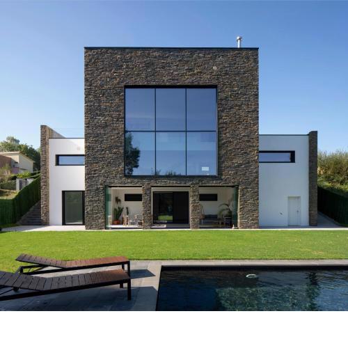 Casa moderna con piscina y vistas al bosque.