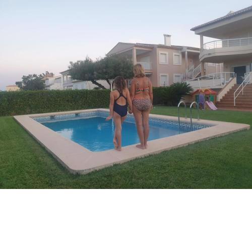primera línea de la playa de oliva con jardín y piscina.